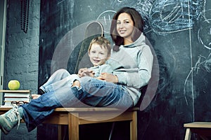 little cute boy in glasses with young real teacher, classroom studying, lifestyle people concept