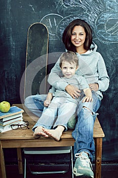 little cute boy in glasses with young real teacher, classroom studying, lifestyle people concept