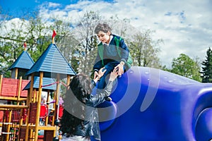 Little cute boy is having fun outdoor in summer. Playing in children zone in amusement park.