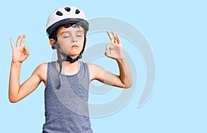 Little cute boy kid wearing bike helmet relax and smiling with eyes closed doing meditation gesture with fingers