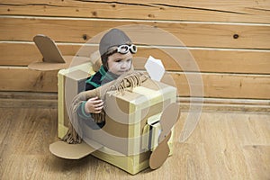 Little cute boy playing with a cardboard airplane