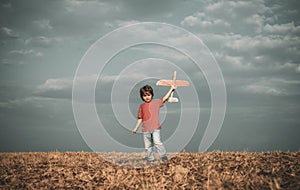 Little cute boy playing with a toy airplane. The concept of child kindness and childhood. Children run with plane on