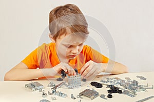 Little cute boy plays with mechanical starter kit at table