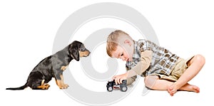 Little cute boy plays a toy car with his puppy