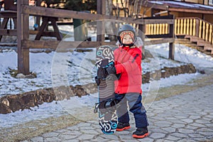 Little cute boy is ready for snowboarding. Activities for children in winter. Children`s winter sport. Lifestyle