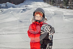 Little cute boy is ready for snowboarding. Activities for children in winter. Children`s winter sport. Lifestyle