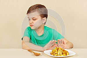 Little cute boy refuses to eat french fries