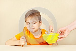 Little cute boy refuses to eat porridge