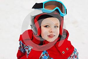 Little cute boy with skis and a ski outfit. Little skier in the