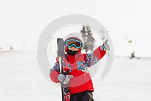 Little cute boy with skis and a ski outfit. Little skier in the