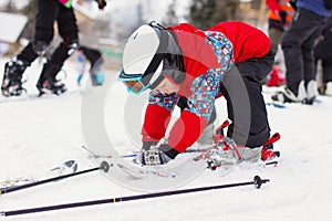 Little cute boy with skis and a ski outfit. Little skier in the