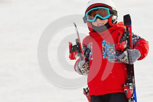 Little cute boy with skis and a ski outfit. Little skier in the