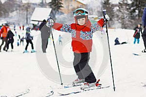 Little cute boy with skis and a ski outfit. Little skier in the