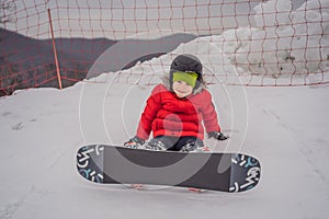 Little cute boy snowboarding. Activities for children in winter. Children`s winter sport. Lifestyle