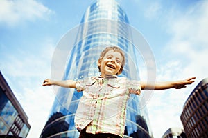 Little cute boy standing near business building, smiling happy, modern lifestyle people concept