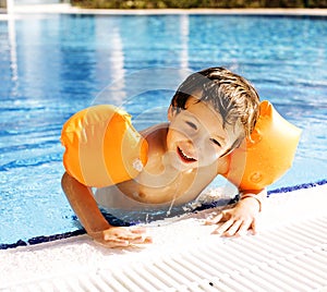 Little cute boy in swimming pool wearing handcarves photo