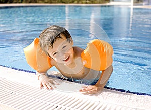 Little cute boy in swimming pool wearing photo