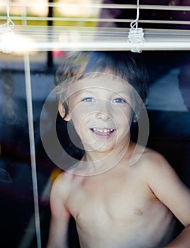 Little cute boy throught window