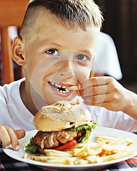 little cute boy 6 years old with hamburger and french fries maki