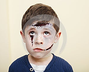 little cute child with facepaint on birthday party, zombie Apocalypse facepainting, halloween preparing concept