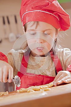 Little cute child girl chef making handmade cakes. The child learns to cook. Food, Ñooking process, sweets concept