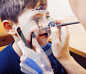 Little cute child making facepaint on birthday party, zombie Apo