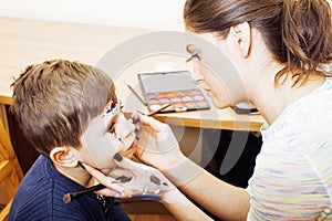 Little cute child making facepaint on birthday party, zombie Apo