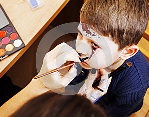 Little cute child making facepaint on birthday party, zombie Apo