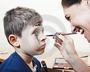 Little cute child making facepaint on birthday party, zombie Apocalypse facepainting, halloween preparing concept