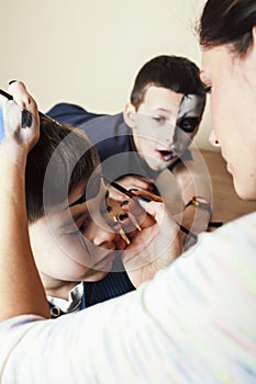 little cute child making facepaint on birthday party, zombie Apocalypse facepainting, halloween preparing concept