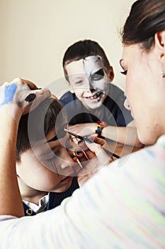 little cute child making facepaint on birthday party, zombie Apocalypse facepainting, halloween preparing concept