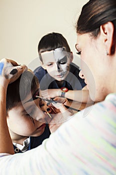 little cute child making facepaint on birthday party, zombie Apocalypse facepainting, halloween preparing concept