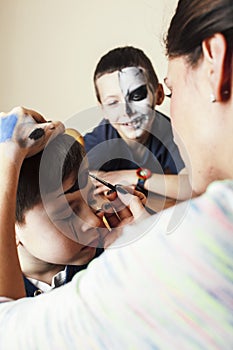 little cute child making facepaint on birthday party, zombie Apocalypse facepainting, halloween preparing concept