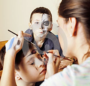Little cute child making facepaint on birthday party, zombie Apocalypse facepainting, halloween preparing concept