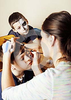 Little cute child making facepaint on birthday party, zombie Apocalypse facepainting, halloween preparing concept