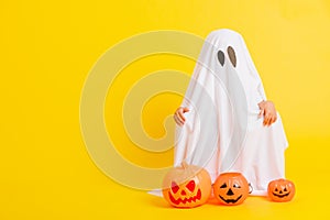 Little cute child with white dressed costume halloween ghost scary he holding orange pumpkin ghost