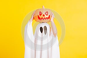 Little cute child with white dressed costume halloween ghost scary he holding orange pumpkin ghost on hand