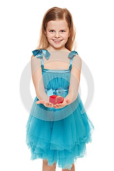 Little cute girl in blue dress holding a gift box, isolated on the white background