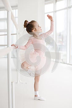 Little cute girl in class in ballet studio