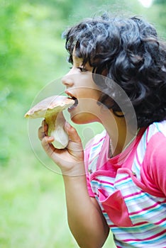 A little cute girl is eating mushroom