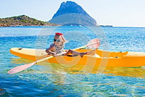 Little cute girl enjoy swimming on yellow kayak in