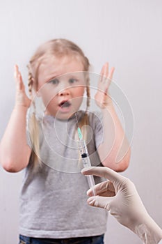Little cute girl fearing of injection. Vaccination of children.