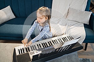 Little cute girl having lesson at piano at school of music.