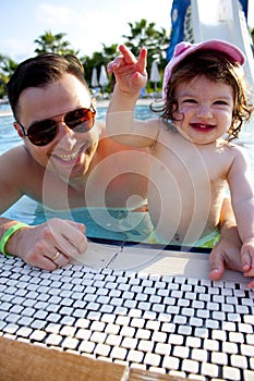 Little cute girl and her dad having fun in the pool.Share the summer spirit