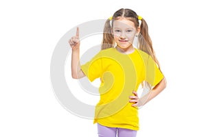Little cute girl keeps pointing her finger at copy space. Isolated on white background.