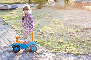 Little cute girl outdoors with a toy car on a sunny day
