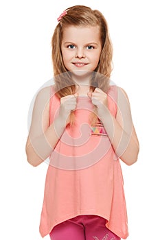 Little cute girl in a pink shirt holds hands hair, isolated on white background