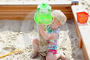 Little cute girl playing in sandbox