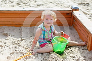 Little cute girl playing in sandbox