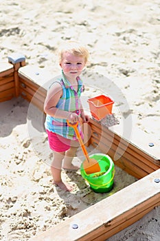 Little cute girl playing in sandbox